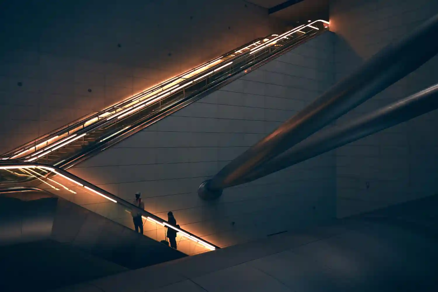 Two professionals moving through a modern office atrium